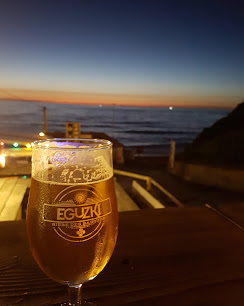 Verre de bière Eguzki en terrasse au coucher du soleil mauve-orangé sur l'Atlantique, Le Miam Acotz
